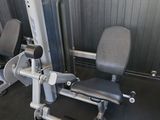 des appareils de musculation gris et noirs dans une salle de sport avec un mur en briques