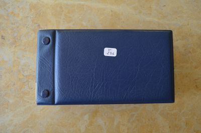 un étui en cuir bleu sur lequel est collé un autocollant blanc