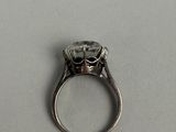 a silver ring with a diamond in it on a table