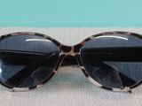 leopard print sunglasses with black lenses on a gray surface