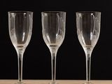 trois verres à vin vides posés sur une table en bois