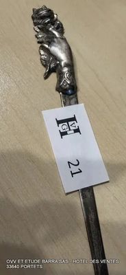 une cuillère en argent sur laquelle est accrochée une étiquette, posée sur une table