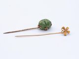 a close up of a pair of hair pins on a white surface