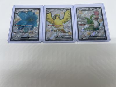 three pokemon cards are sitting on top of each other