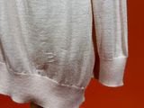 a white shirt on a wooden stand against a red wall