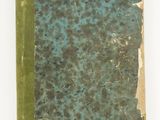 an old book with a green cover sitting on a white surface