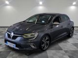 Une voiture grise est garée dans une grande pièce au sol carrelé.