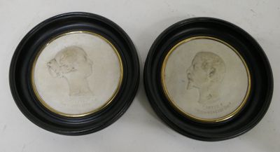 deux portraits encadrés représentant un homme et une femme, dans des cadres noirs