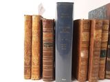 many old books that are on a shelf next to each other