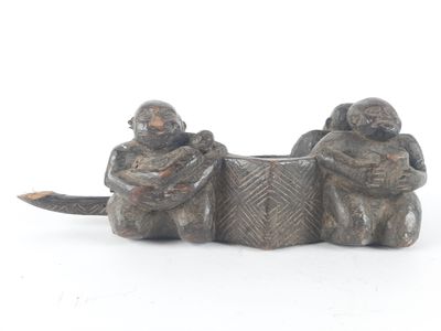 two figurines of monkeys sitting next to each other