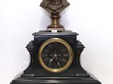 a clock with a bust of a man on top of it
