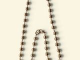 a close up of a necklace and a bracelet on a white surface