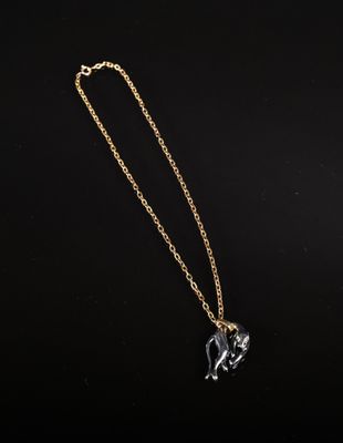 un collier en or orné d'un pendentif en forme de cheval sur fond noir