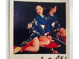 a picture of two women in kimono robes sitting on a bed