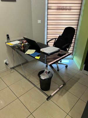 a glass desk with a laptop on it in a room