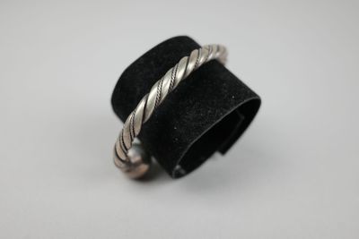 un gros plan d'une bague posée sur une surface blanche, avec un anneau noir