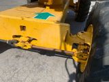 a yellow tractor with a green arrow on it