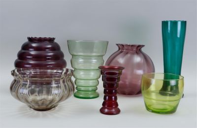 many different colored glass vases on a white surface