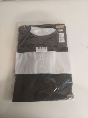 une chemise rayée noir et blanc posée sur une table blanche