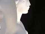 a white sculpture of a woman with a bird on her head
