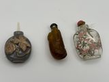 three small glass bottles sitting next to each other on a table
