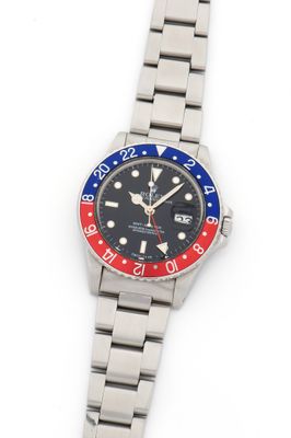 a close up of a wrist watch with a red, white and blue bezel
