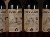 three bottles of red wine are lined up on a table