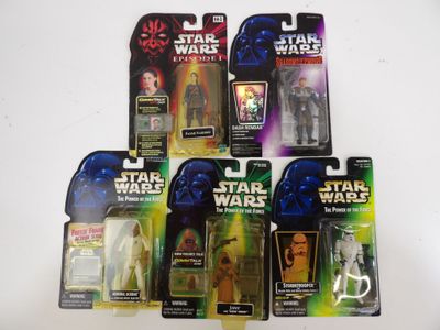 cinq figurines de Star Wars sont alignées sur une surface blanche