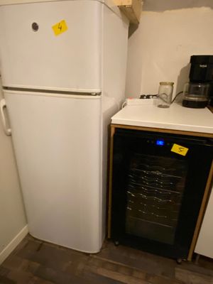 a white refrigerator and a black refrigerator freezer in a kitchen