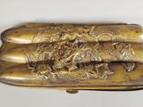 a gold colored box with a dragon design on it