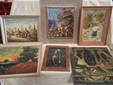 de nombreux tableaux exposés sur une table recouverte d'une nappe blanche