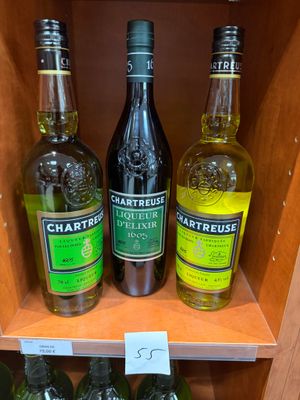Plusieurs bouteilles d'alcool sont posées sur une étagère dans un magasin.