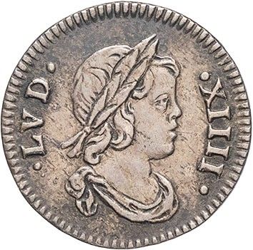 a silver coin with a woman wearing a hat on top of it