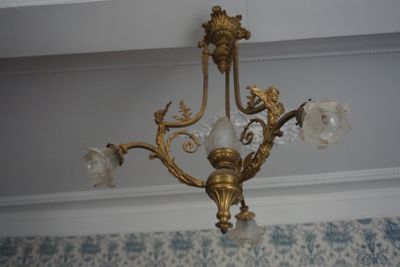 un lustre en or suspendu au plafond d'une pièce