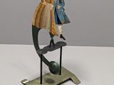sculpture représentant un homme et une femme sur un globe terrestre posé sur un socle