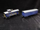 two toy trains sitting side by side on a black background