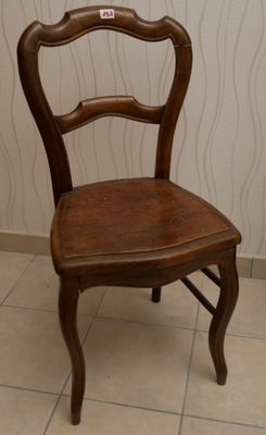 une chaise en bois posée sur un sol carrelé