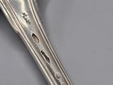 a silver spoon with holes in it sitting on a table