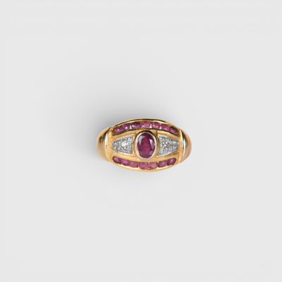 gros plan d'une bague en or avec un rubis et des diamants