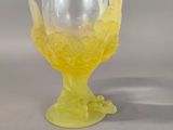 a glass vase with a yellow flower inside of it