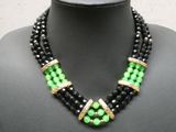 un gros plan d'un collier noir et vert sur un mannequin