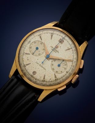 un gros plan d'une montre-bracelet en or avec un bracelet en cuir noir