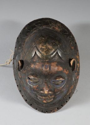 un gros plan d'un masque en bois entouré d'une corde