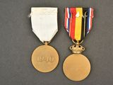 two medals with a ribbon and a medal on a table