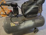 un petit compresseur d'air posé par terre dans un garage