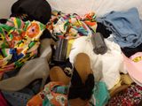 a pile of clothes and shoes on a bed