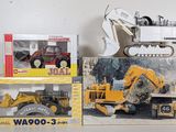 two boxes of toy construction vehicles on a table