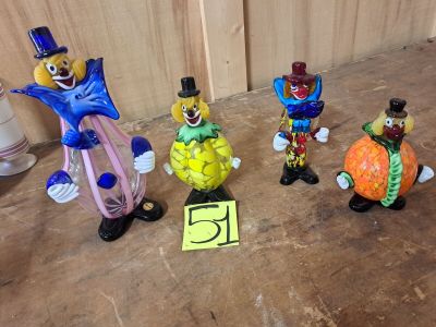 cinq figurines de clowns posées par terre les unes à côté des autres