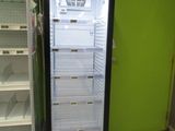 an empty refrigerator in the middle of a green wall