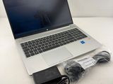 an open laptop computer sitting on top of a table next to a charger